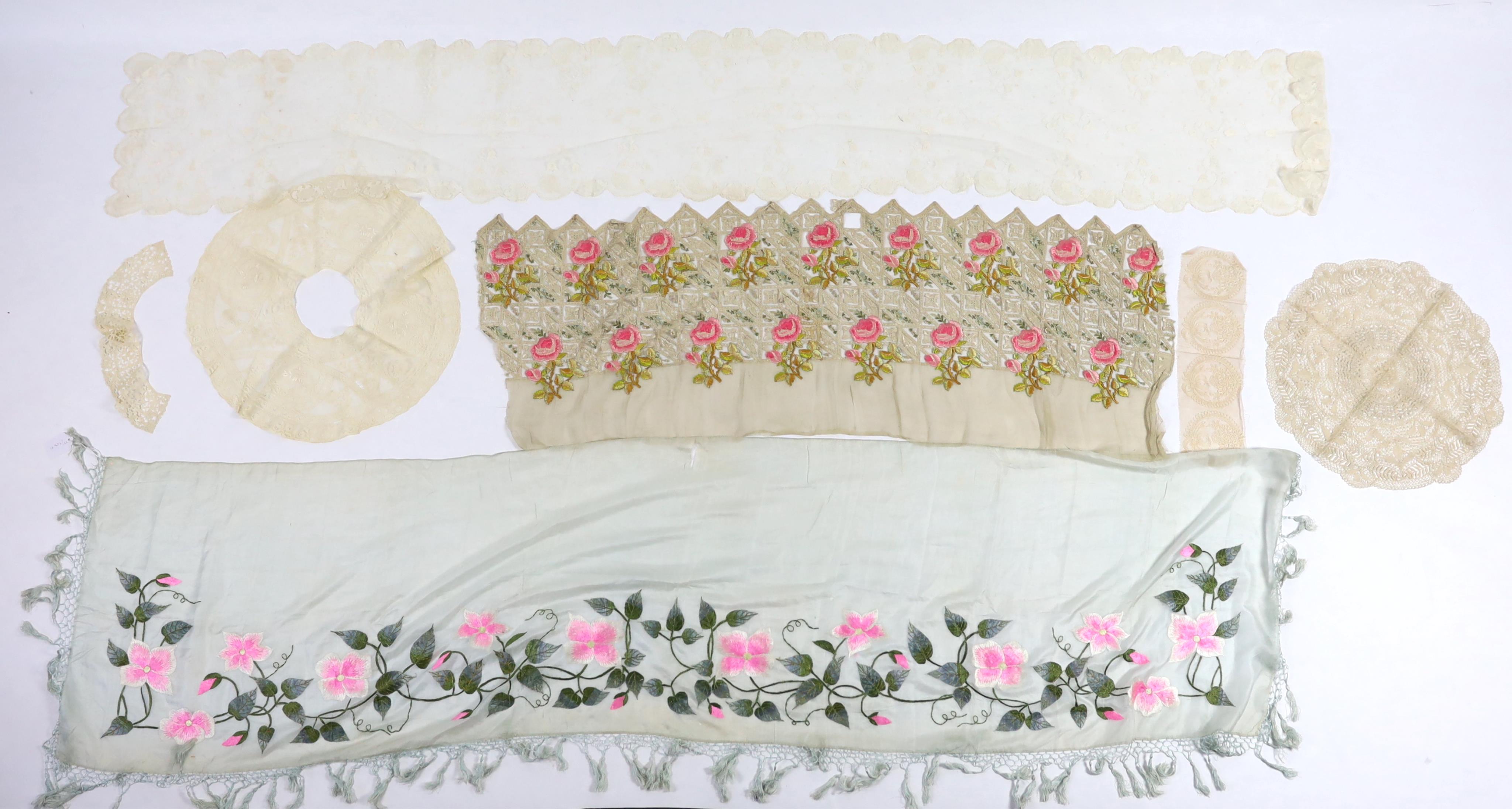 An early 20th century fine spun silk embroidered and fringed pelmet, a lace and polychrome embroidered border, possibly a panel to a dress, a needle run lace stole, a Normandy lace border to a circular mat, a bobbin lace